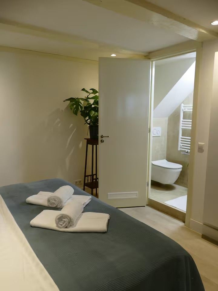 Het bed met doorkijk naar de badkamer