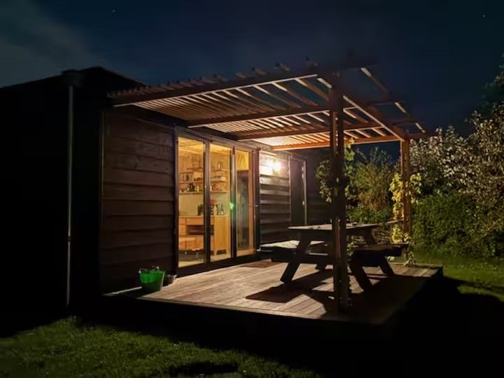 Het huis met verlichte pergola in de avond