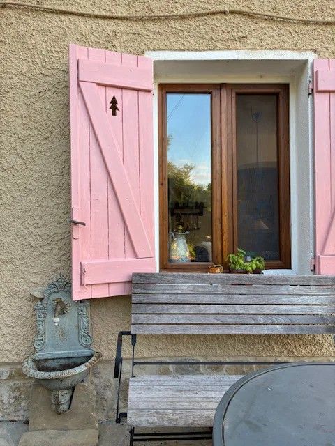 Raam met roze luiken
